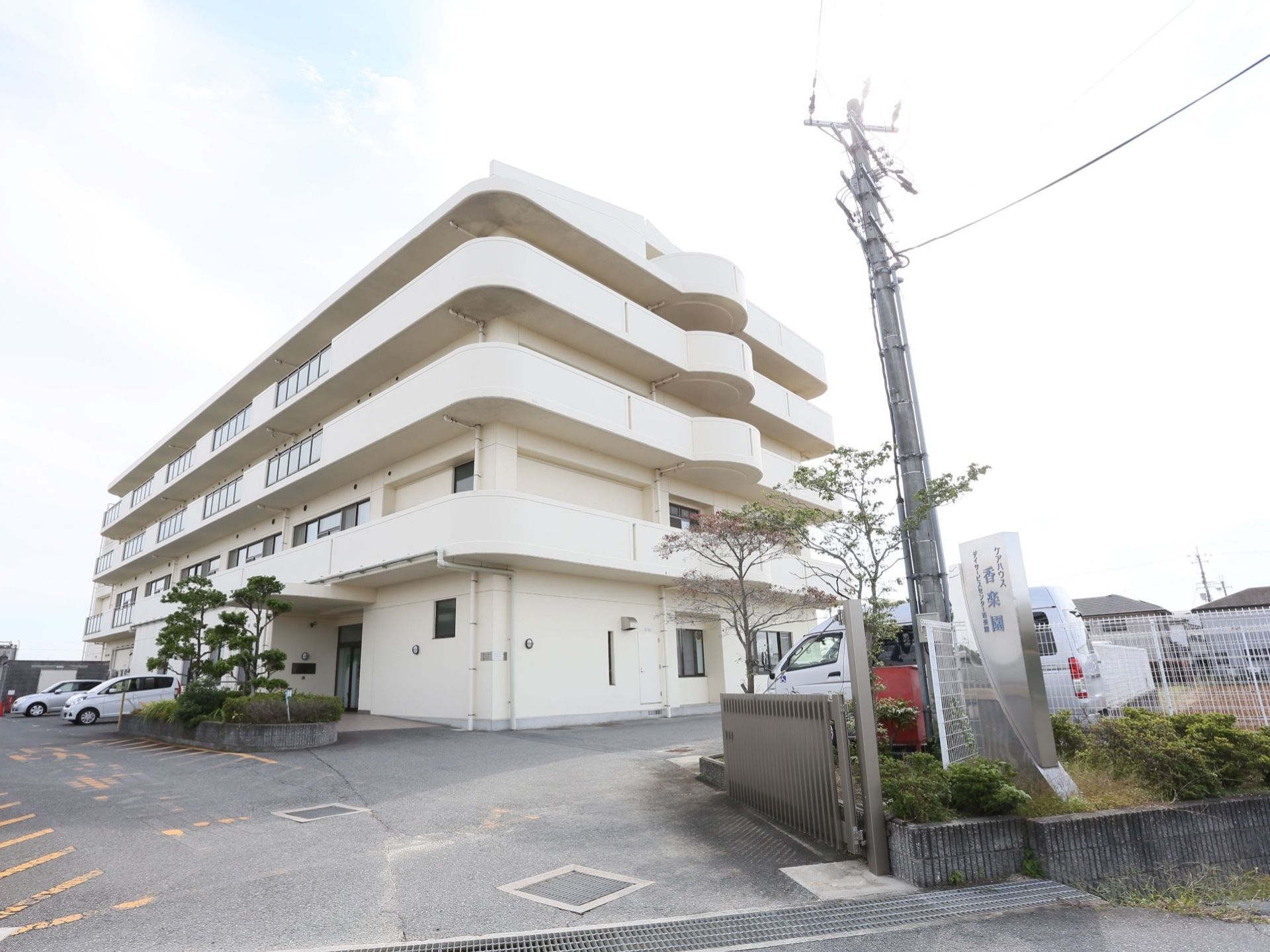 清潔感ある白い外壁の５階建て施設である。駐車場を完備しており、遠方のご家族様にもお越しいただきやすい環境である。