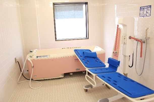 ピンクを基調とした浴室には窓から日差しが入り、さらに明るい雰囲気が漂っている。壁際に特殊介助浴槽が置いてある。
