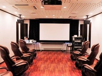 正面には大型のスクリーンがあり、両サイドに黒いいすがセットされている。