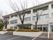 施設は３階建てで、外壁は白色のレンガ調である。玄関ドア前にまで屋根が付けられている。大きな木が植えてある。