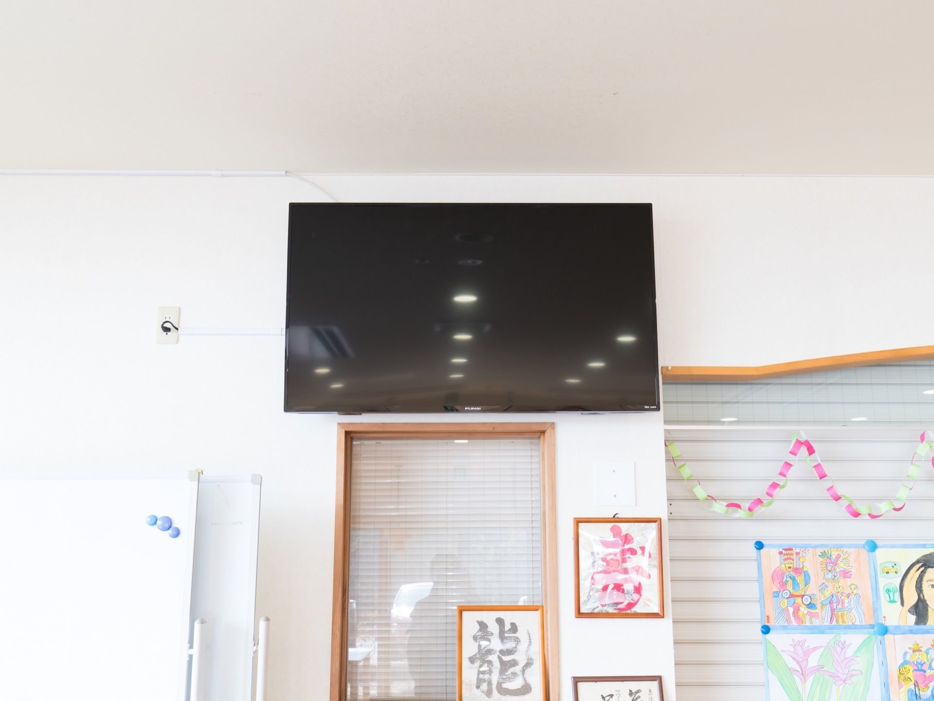 テレビモニターは壁の高い位置に設置されているので、どの位置に座っても見やすくなっている。サイズも大きいので楽に視聴できる。