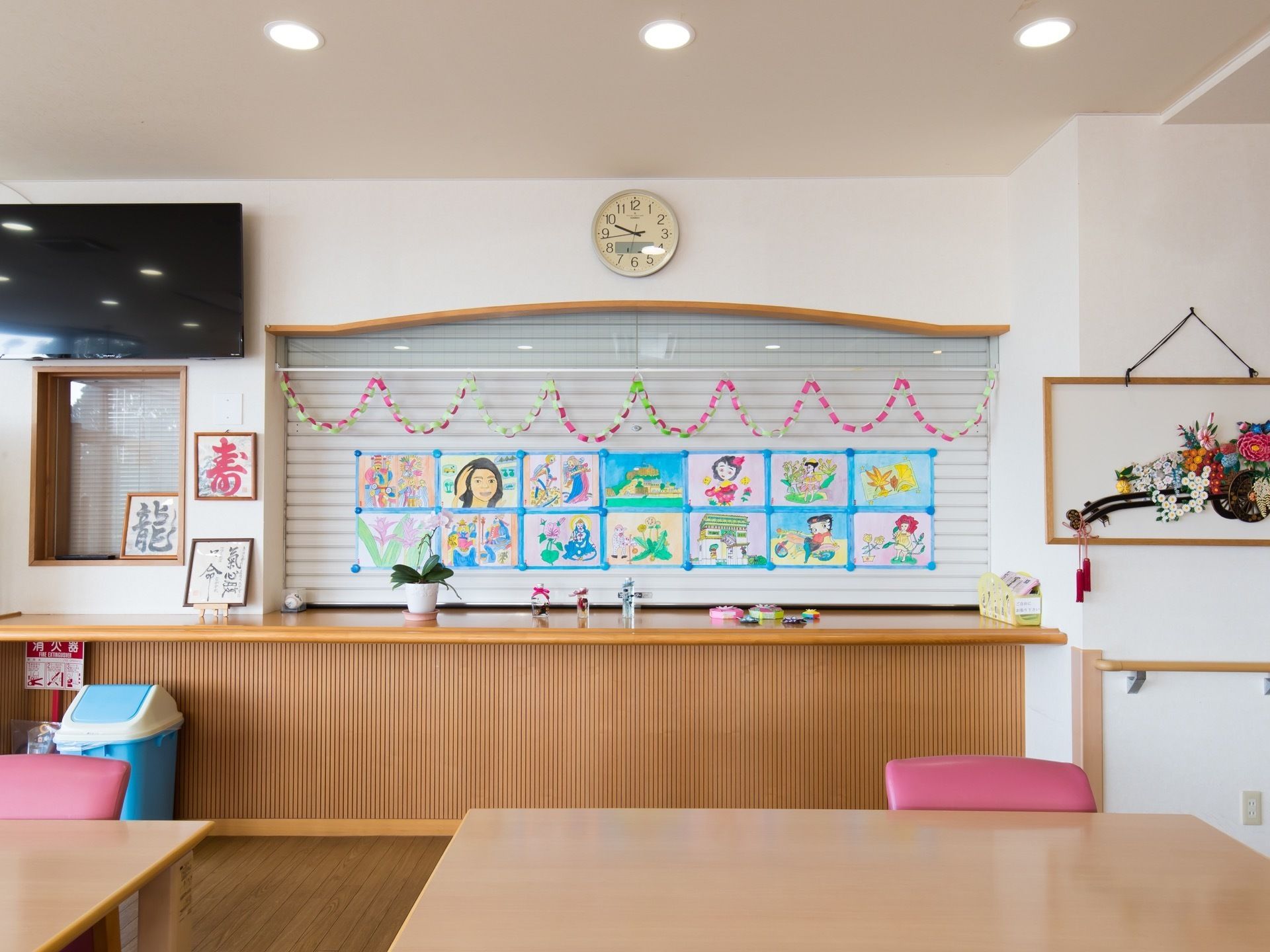 食堂の壁面には絵画や手芸作品などが飾られている。部屋全体があたたかみのあるアットホームな雰囲気になっている。