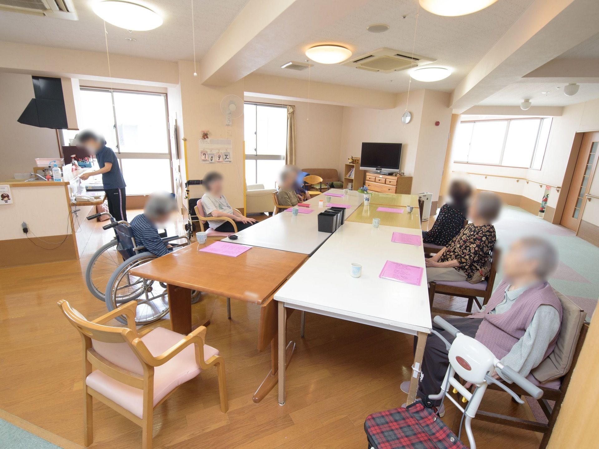 テレビが観やすいように、テーブルと椅子が並べられている。奥には小さなキッチンスペースが備え付けられている。