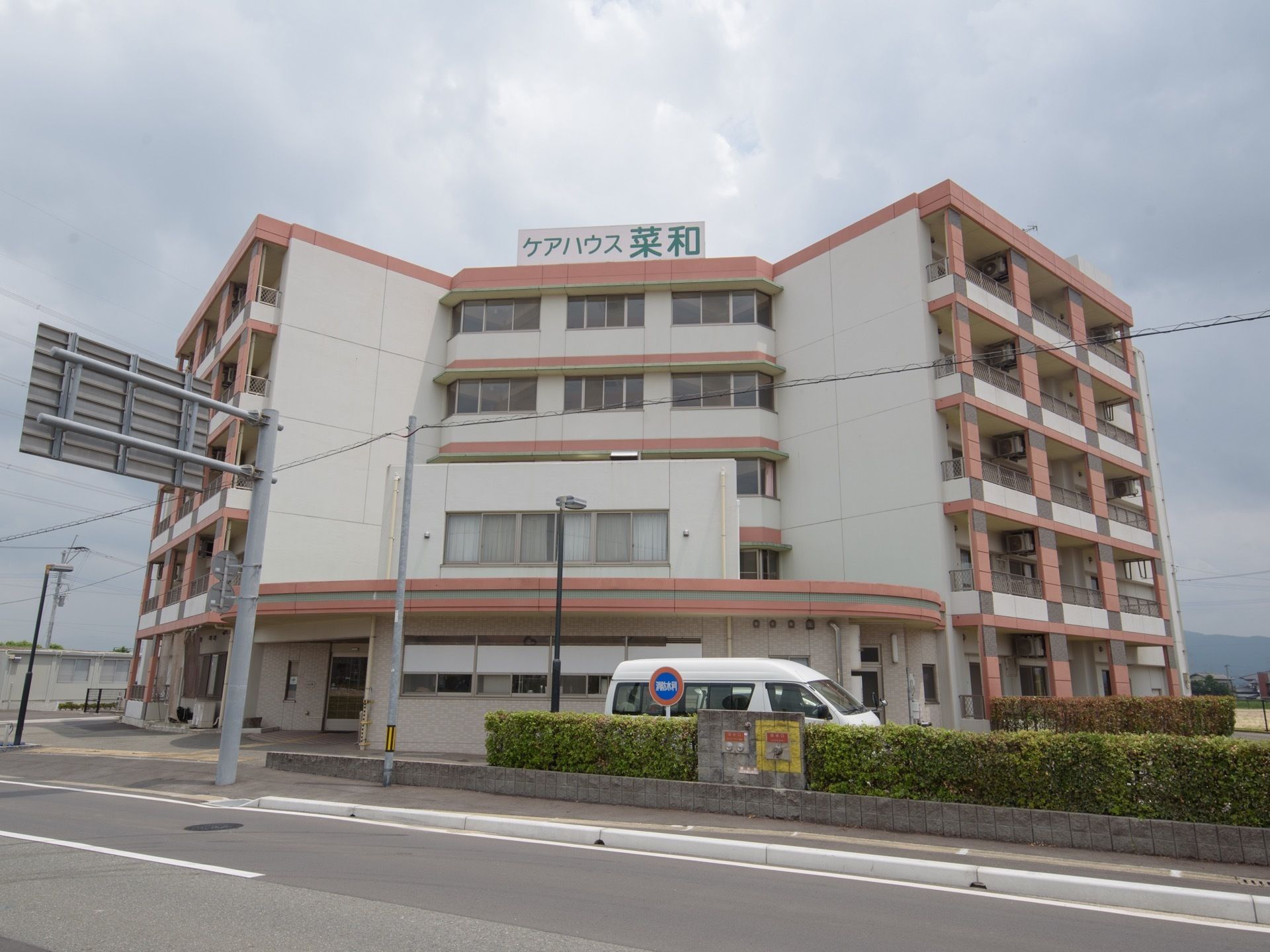広い通りに面した５階建ての施設である。屋上部分に施設名の入った看板が設置されている。駐車場も完備されているため、車での来訪にも対応できる。