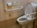 センサー付きのトイレになっている。両側に手すりがついている。手すりの下にあるナースコールは転倒時でも押せる位置についている。
