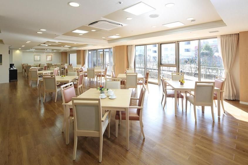 ダイニングルームのテーブルには、椅子が４脚、それぞれ向き合うかたちで配置されている。シートはピンクとグレーとを交互に置いている。