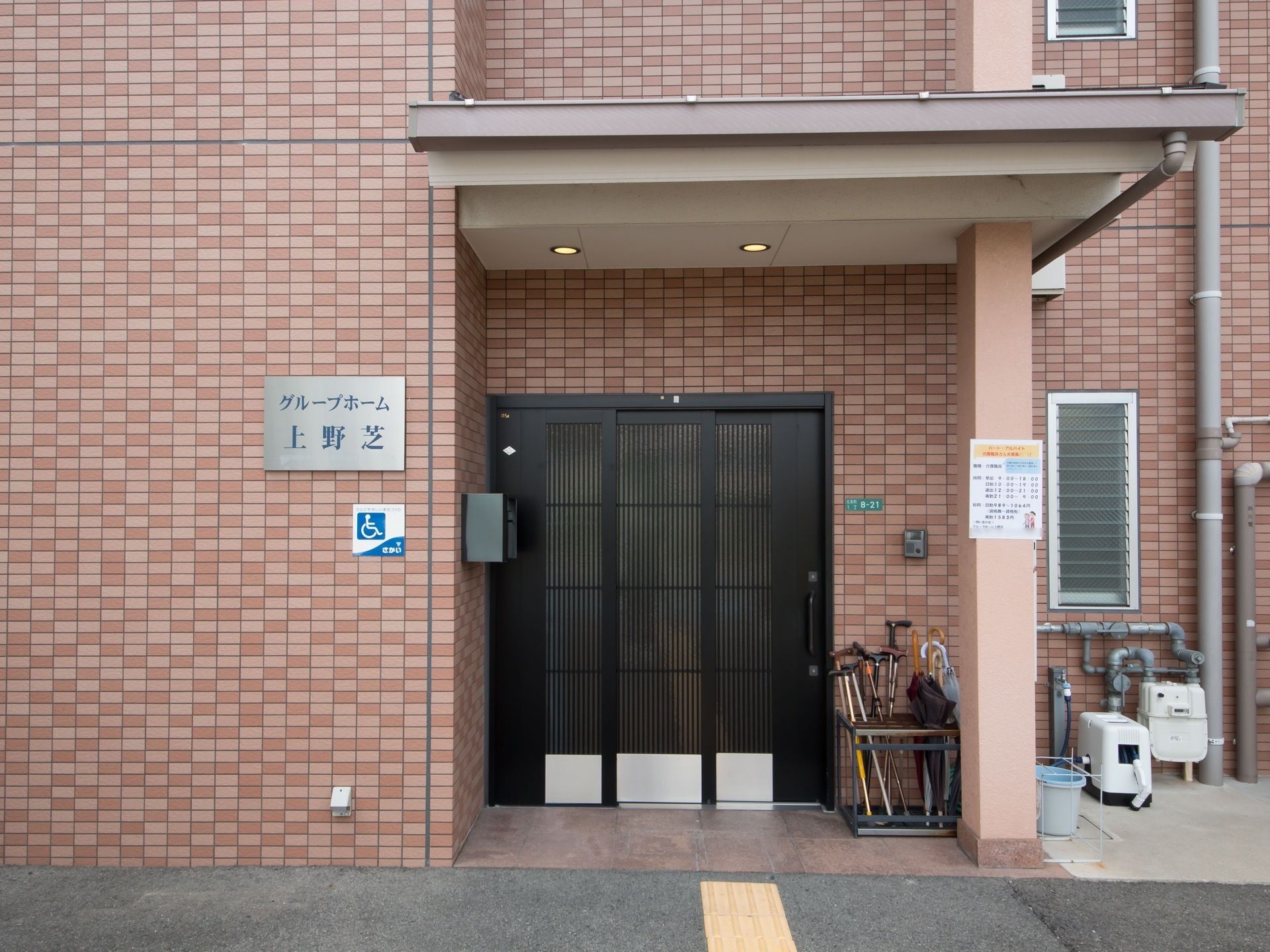 レンガ調の外壁が印象的な施設である。玄関の扉は黒色で施され、館内が見えない造りになっている。点字ブロックも設置。