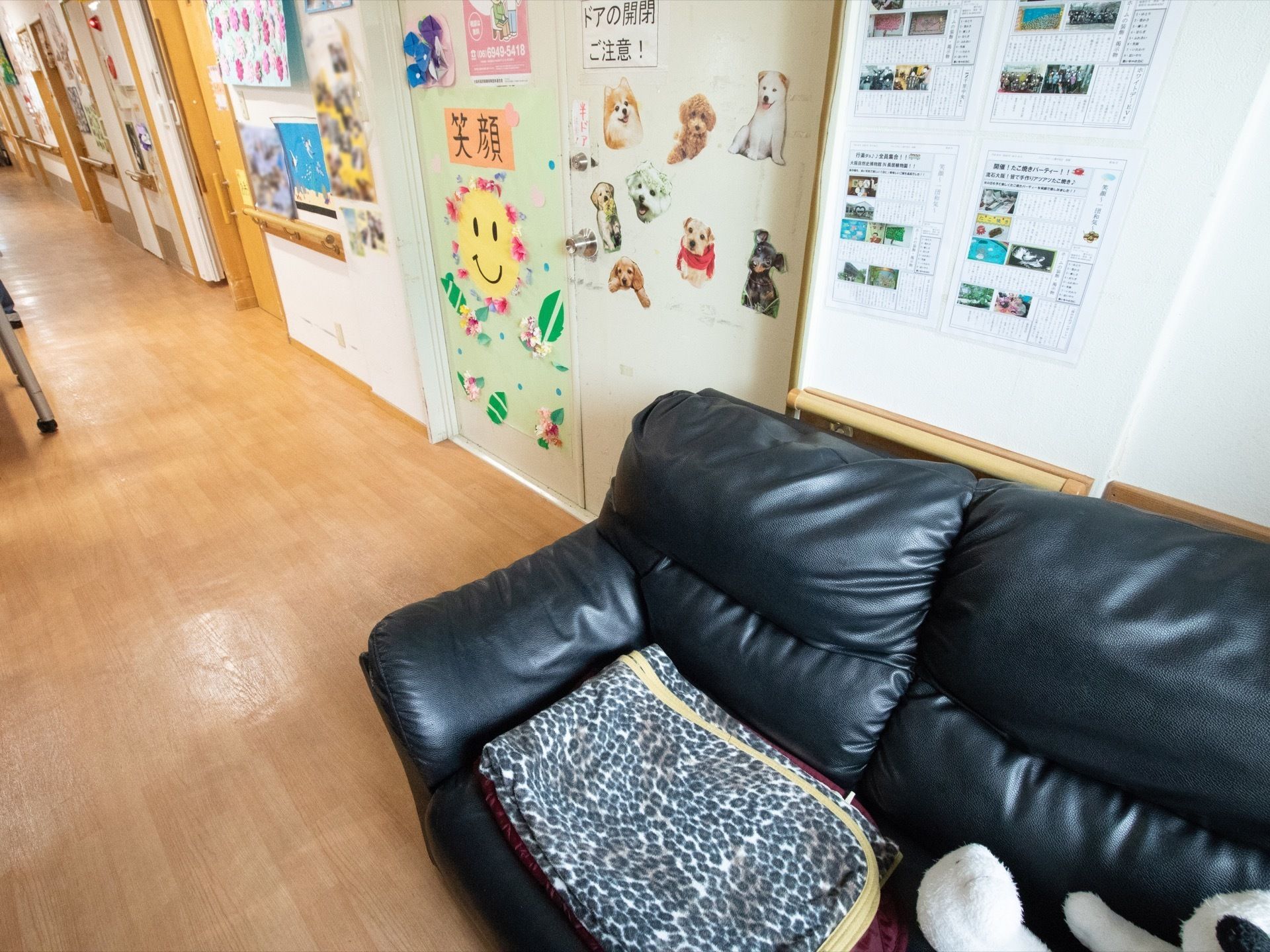 手すりが設置されている。壁や扉にはたくさんの装飾品が飾られている。壁側に黒い革のソファが配置されている。