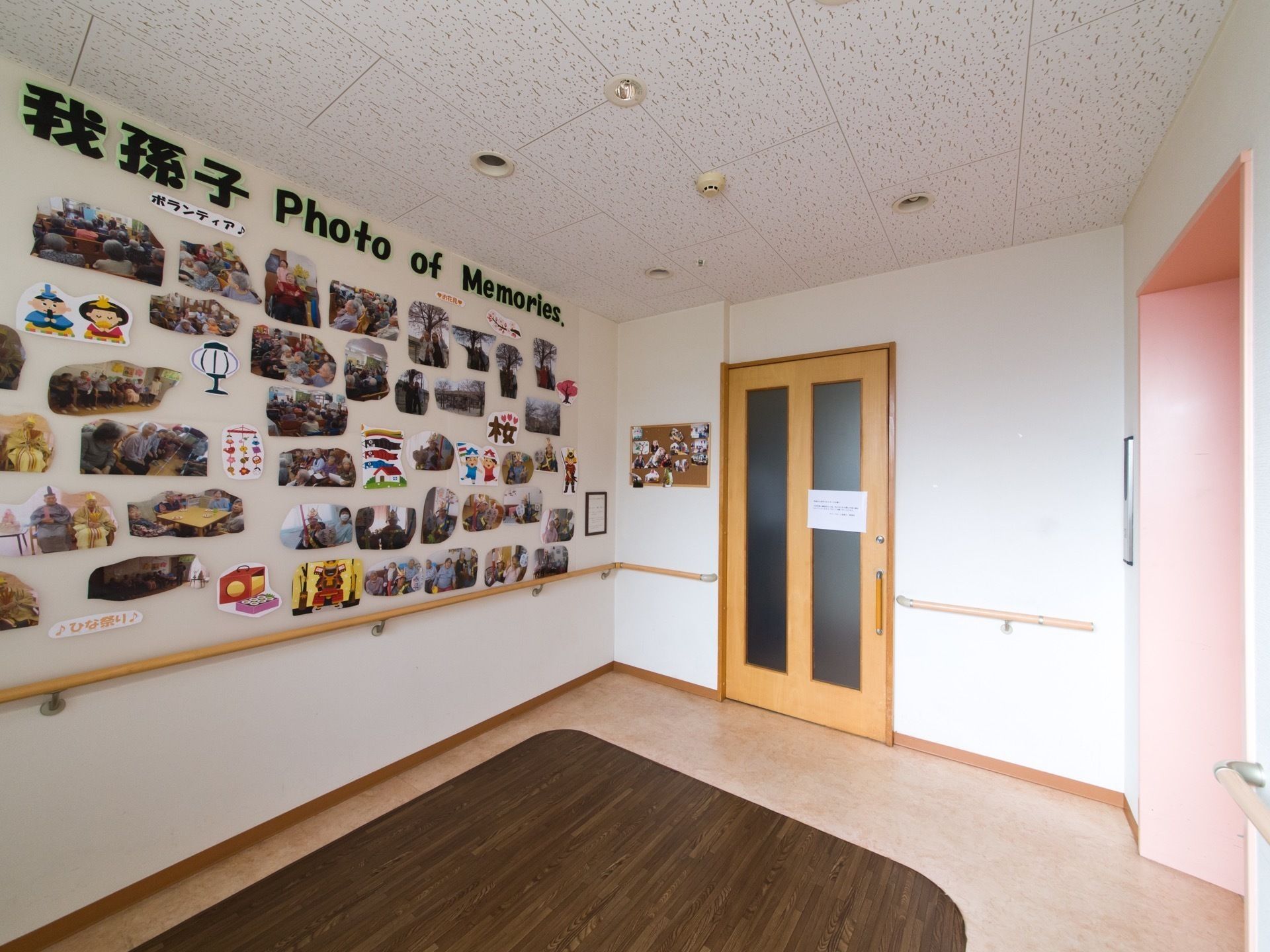 手すりがついた部屋の一角の、壁一面に貼られている写真