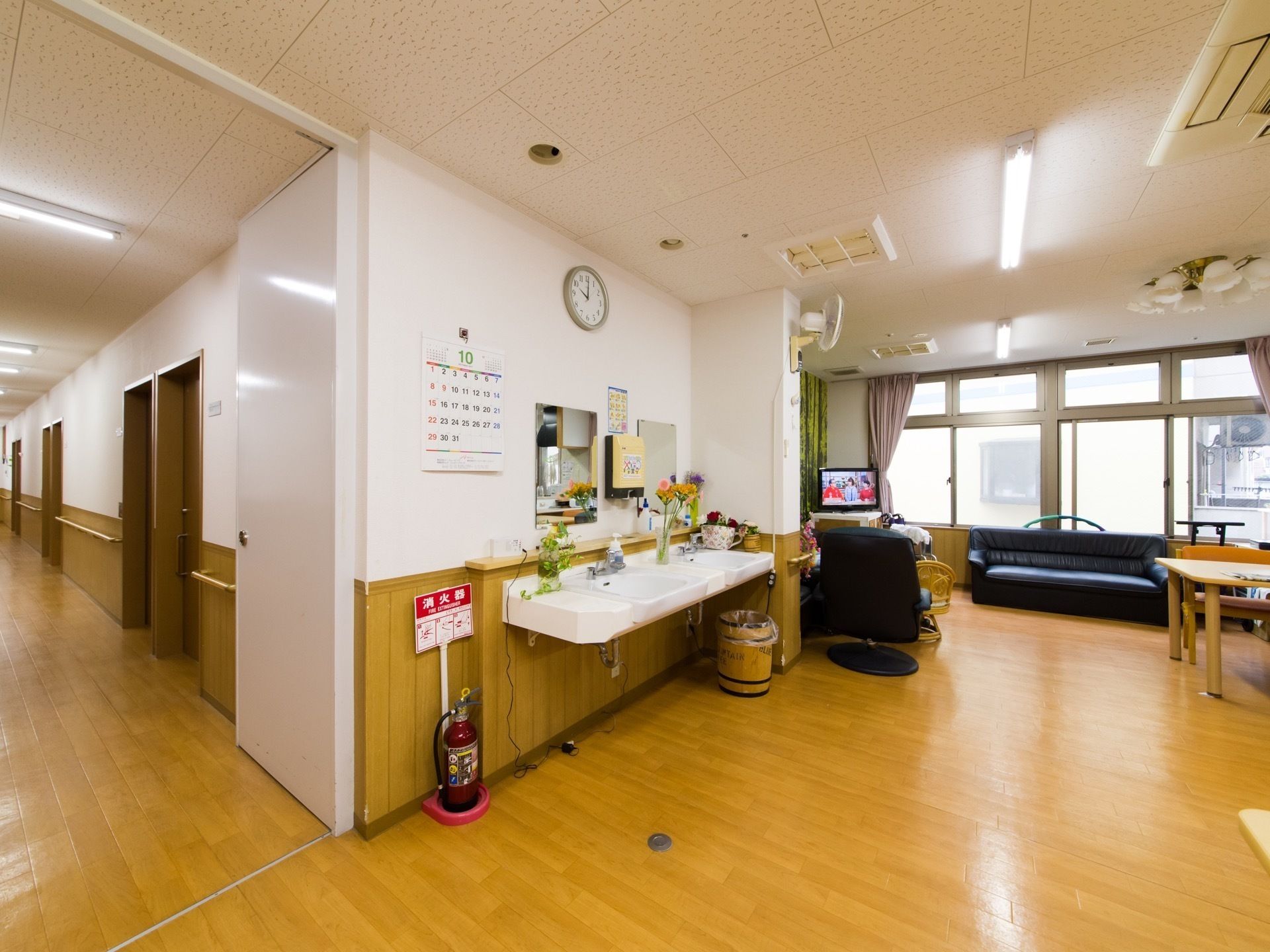 テーブルやソファ、テレビがある一角に鏡と洗面台が二つ並んでいるリビング