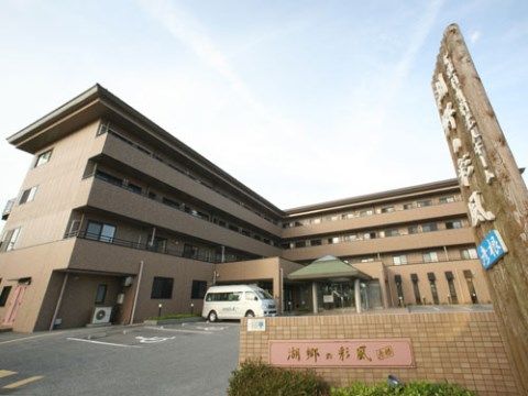 目の前に駐車場があり、Ｌ字型に建てられた四階建ての建物