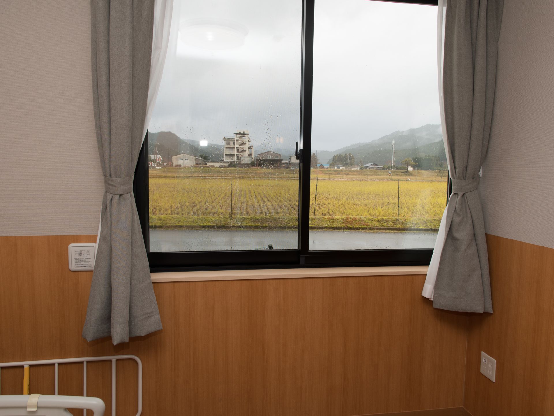 個室の窓からは田んぼの広がるのどかな田園風景が見える。入居者には喧騒から離れた静かな暮らしが提供される。