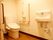 白とライトブラウンでまとめられた落ち着いた雰囲気のトイレである。白い壁には頑丈な手すりが付いている。緊急時のコールボタンもある。