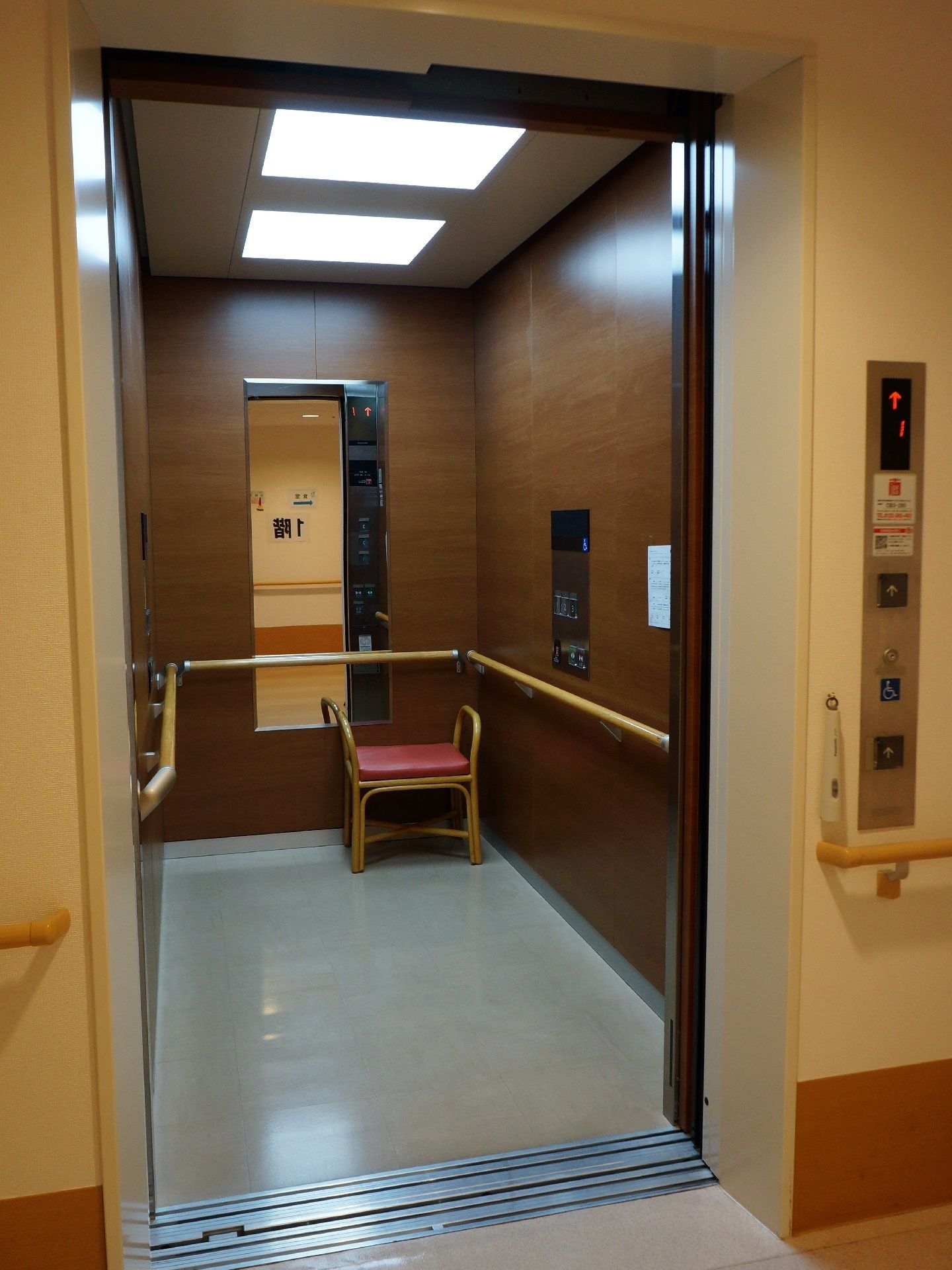 施設内には足の不自由な人のための、バリアフリーのエレベーターを設置している。壁には手すりがあり、腰掛けるためのイスも用意されている。