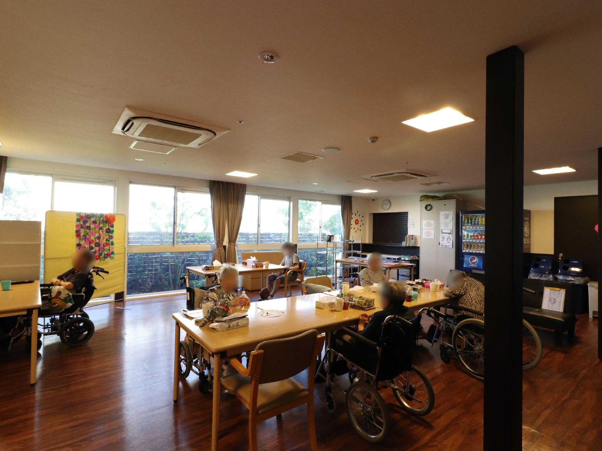 たくさん窓のある明るい空間には、冷暖房や大型液晶テレビが完備されているので快適に食事ができる。自動販売機も完備。