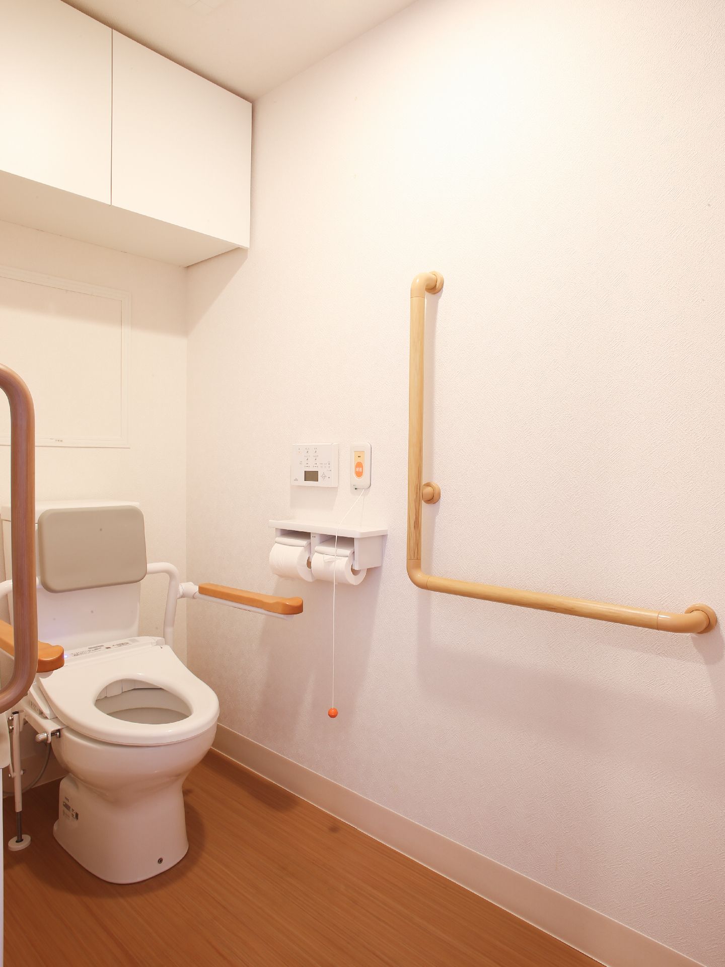 トイレの入り口は引き戸で、便器の両脇や壁には手すりが付けられている。緊急時の呼び出しブザーた備わっている。