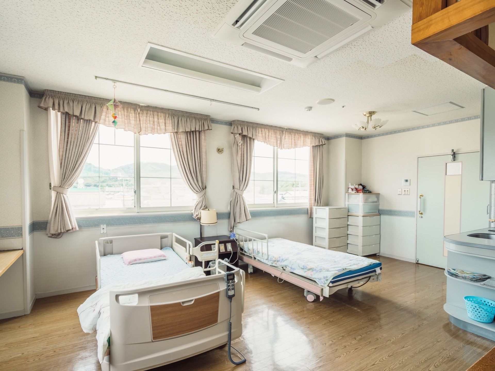 ２人部屋の居室がある。柵で囲まれたベッドと、転落防止柵が１つだけついているベッドが、間隔を空けて置かれている。