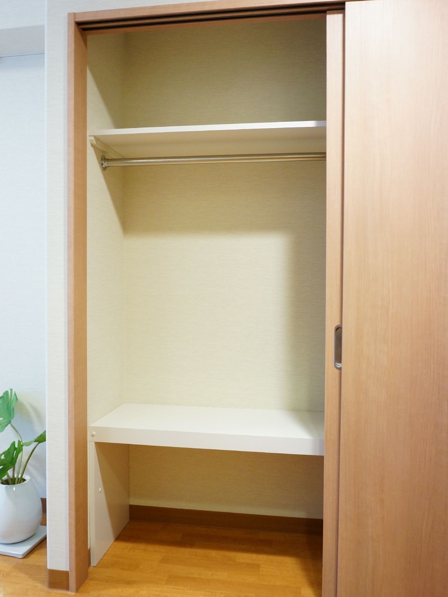 部屋に設置されているクローゼットである。洋服を掛けられるポールや上下に棚があるので、多くの物が収納できる。