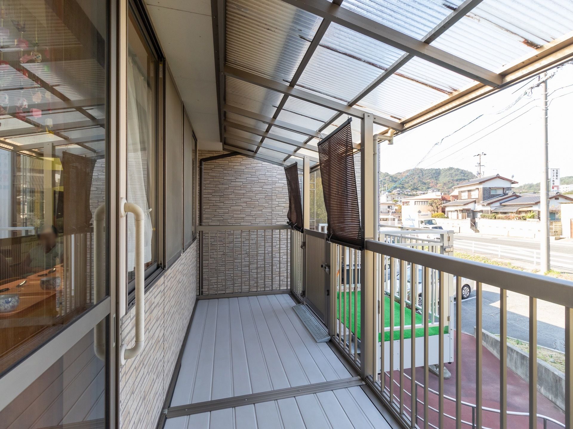 建物の２階にベランダがあり、ベランダの入口は引き戸になっている。ベランダの周りには柵が設置され、リフトも取り付けられている。