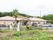 緑の山や自然に囲まれた洋風の平屋建ての建物がある。建物の周囲には植物の多数植えられた広い庭や、アスファルトの広い駐車場がある。