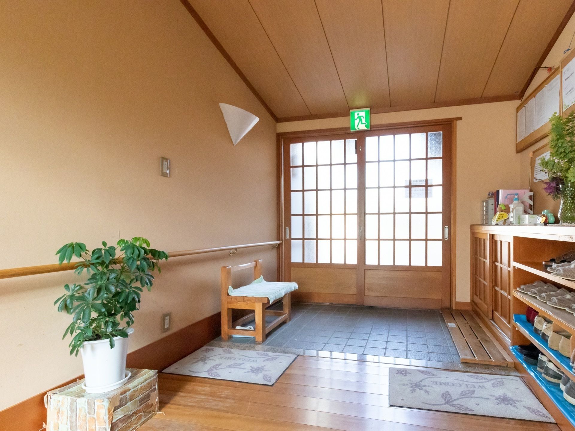 靴箱やベンチを配置して観葉植物を飾っている玄関