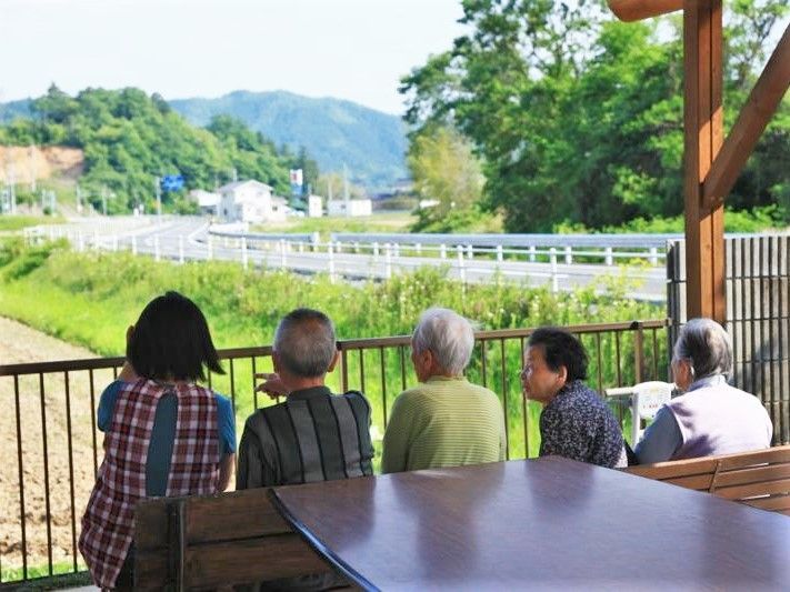 ベンチやテーブルが置かれ、そこから見える景色を楽しんでいる入居者とスタッフ。