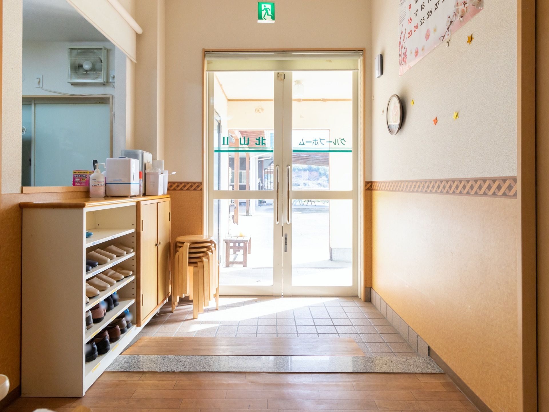 エントランスはフラットな造りとなっており、隅には椅子が複数個用意されている。靴箱の上には、消毒液が用意されている。
