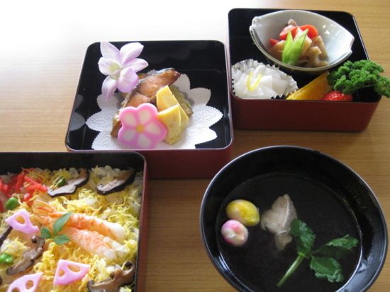 花をあしらった焼き物と、海老や錦糸卵の乗ったちらし寿司とお吸い物のセット