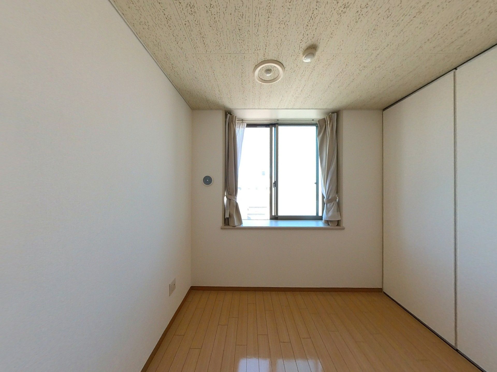 介護ベッドが置かれた居室はフローリングで壁には手すりが付き、クローゼットもついている。
