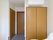洋風の部屋の一画に、２つの両開きのドアと１つの引き戸のドアがある。部屋の天井近くの壁にはエアコンが備え付けられている。