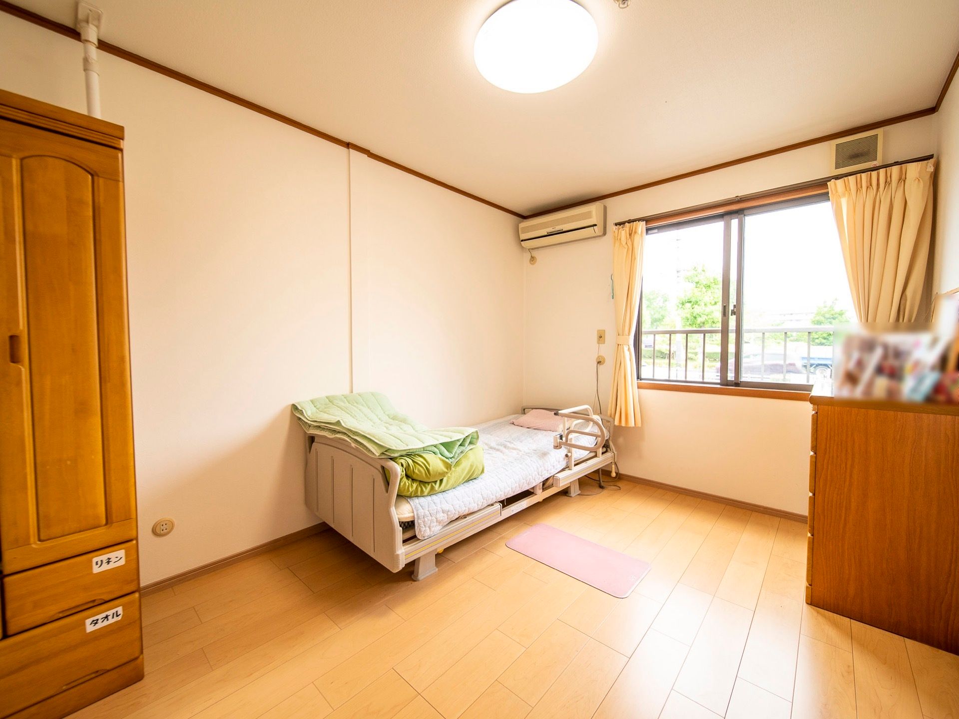 居室の窓は大きく部屋全体に日が差し込む。大きなタンスが備わっており衣類をたっぷりしまうことができる。
