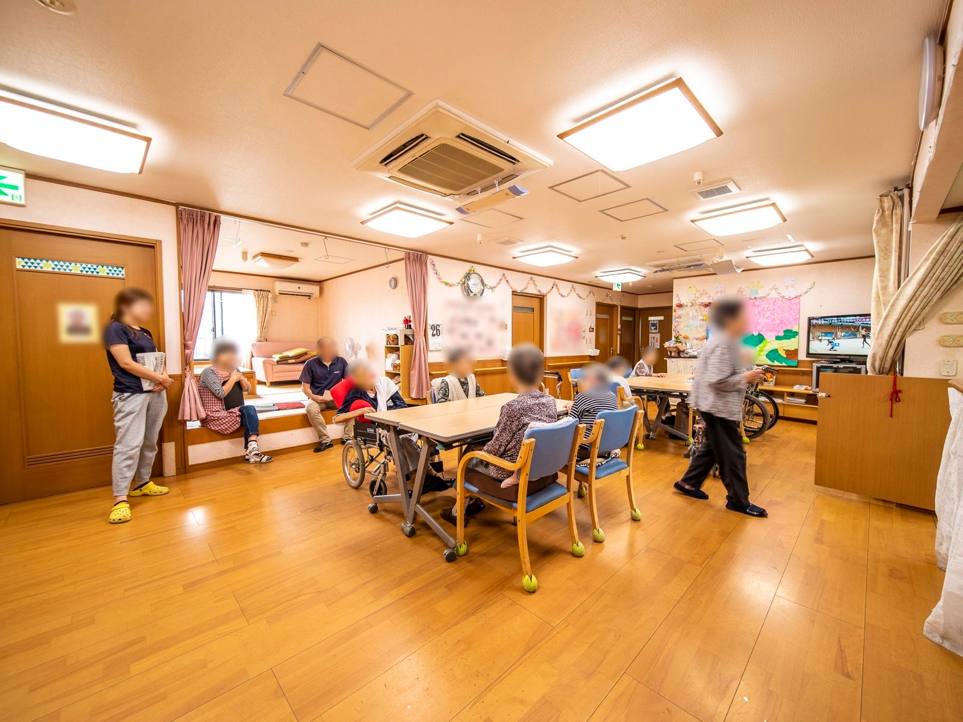 共有スペースではスタッフが入居者様と一緒に会話をしている。笑顔が溢れる温かな雰囲気の中で過ごすことができる。