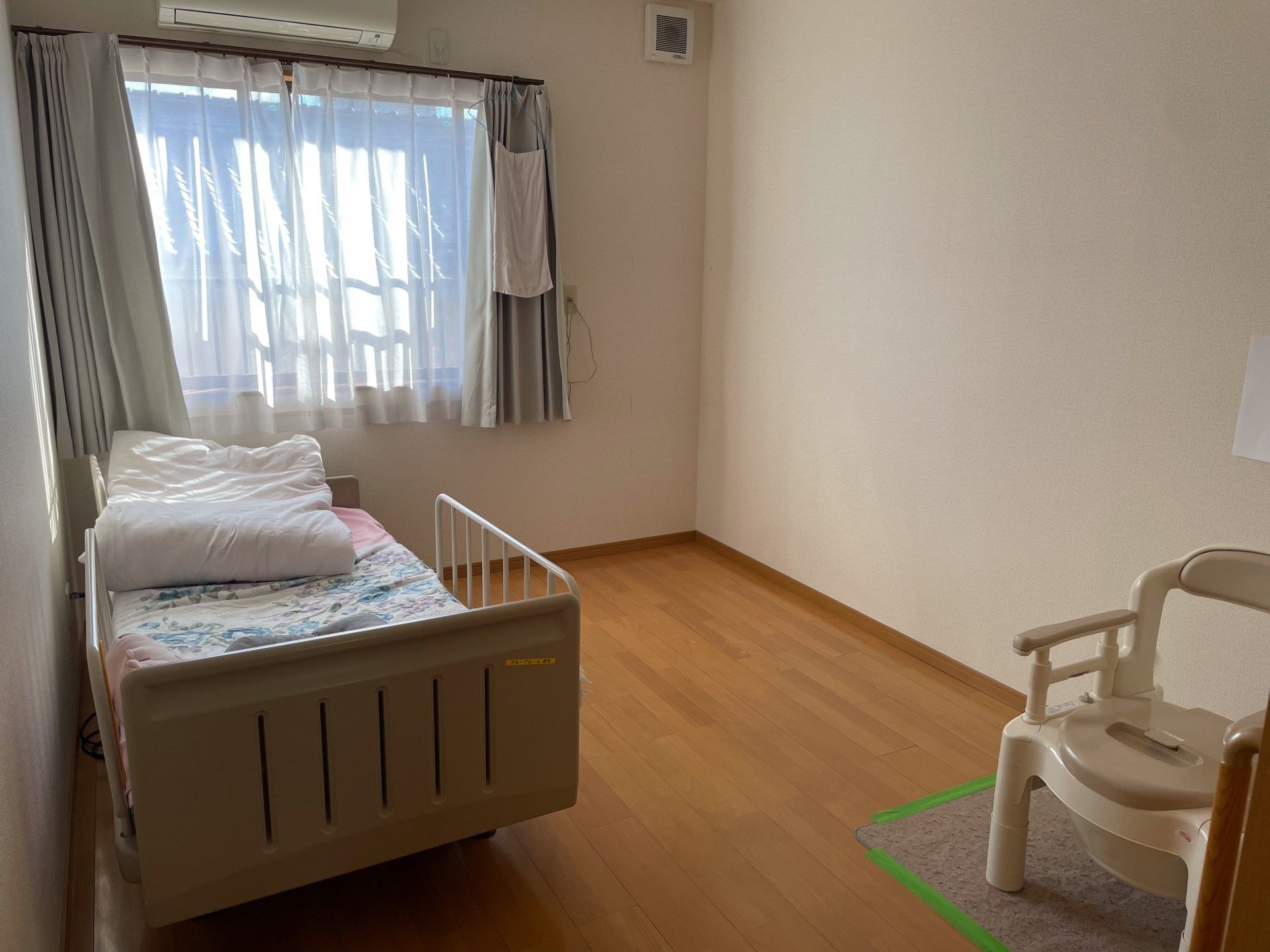 窓際のベッドと椅子の部屋