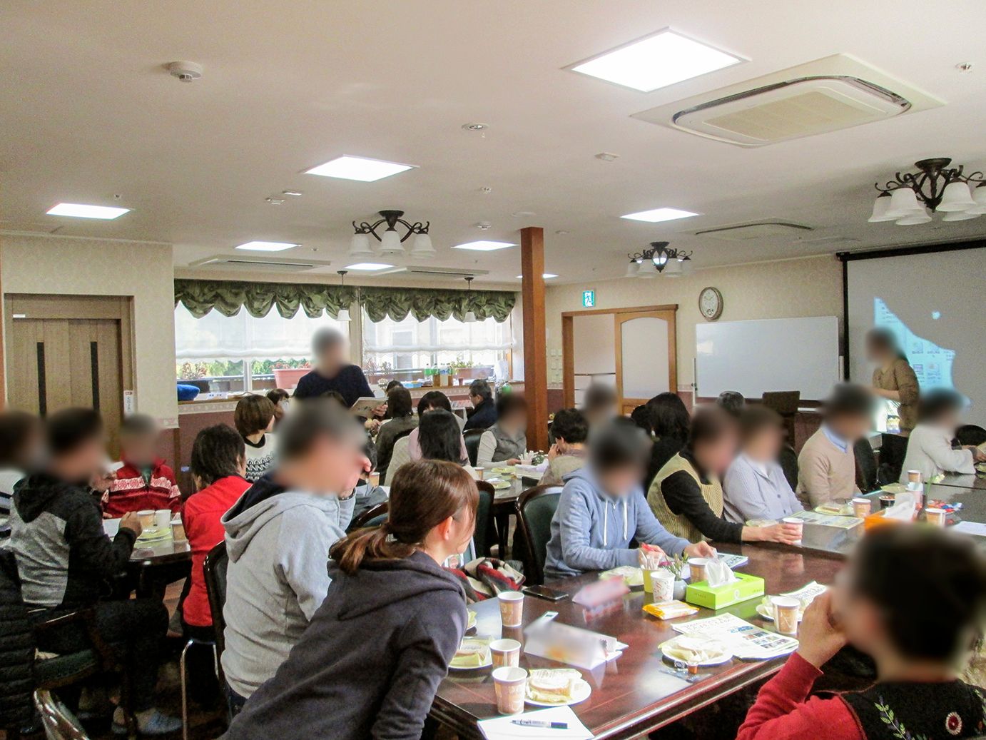 施設では家族会というイベントが開催されており、共有スペースにたくさんの入居者様とそのご家族が集まっている。