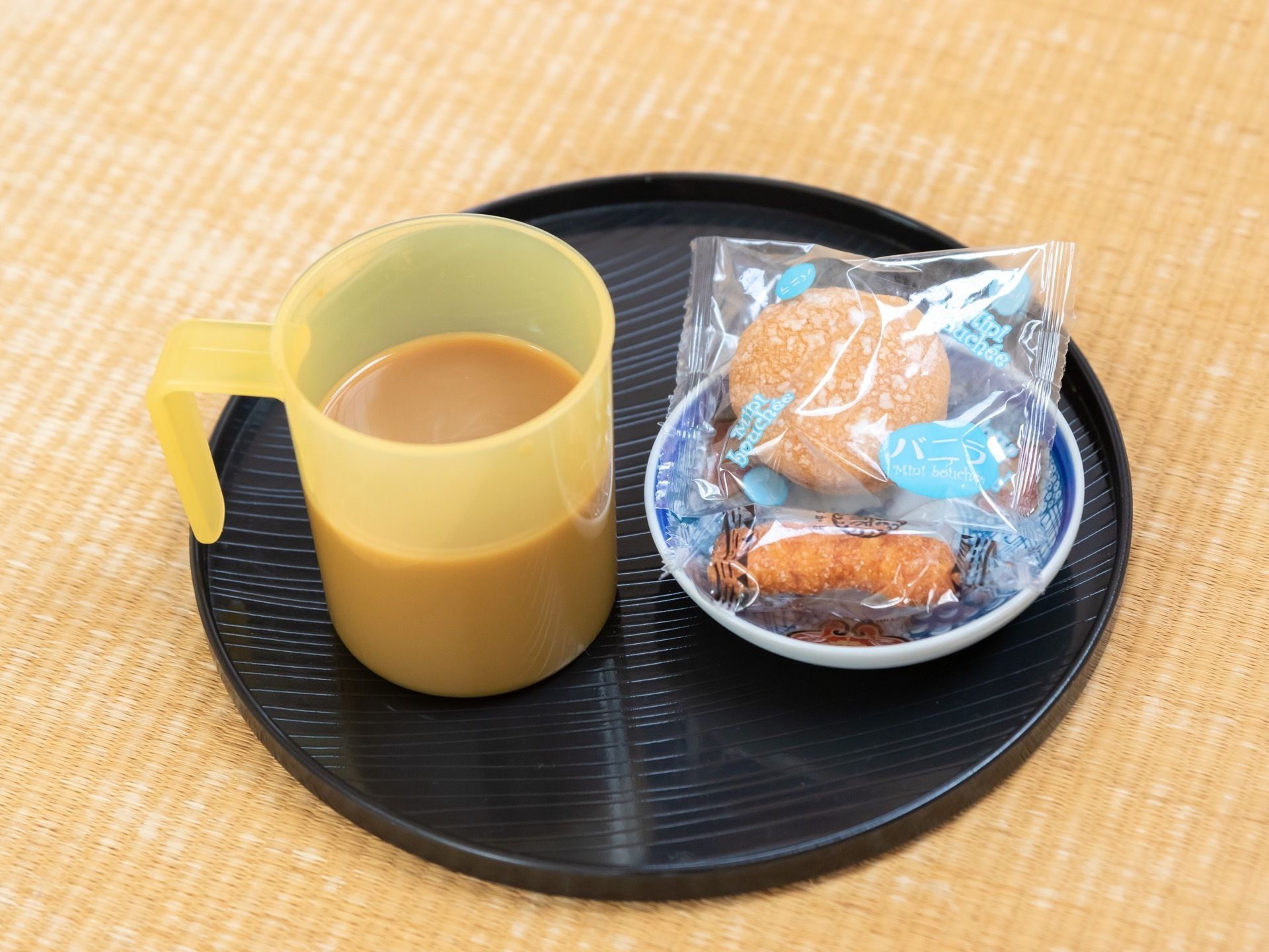 丸いお盆の上に、飲み物とお菓子を用意。お菓子は個包装になっていて、小さな丸い皿に入れられている。