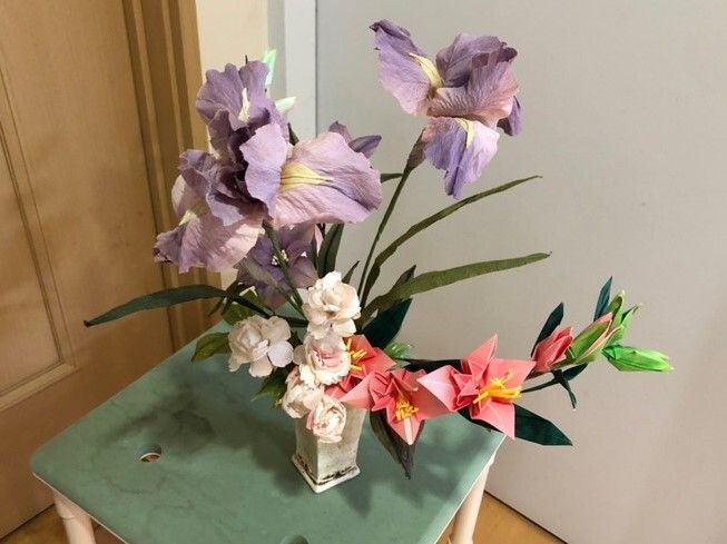 小さな台の上に飾られたピンクのユリや紫のアヤメ、白いカーネーション。どれも紙で作られた作品で一見本物と見間違うほどきれいにできている。