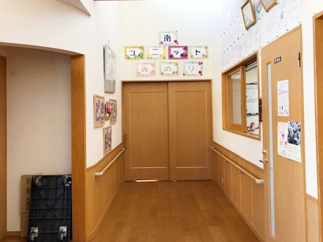 ユニットのドアの上には「南ユニット」と書かれていて、そばにはスタッフがいるカウンターがあり、壁には写真も飾られている。