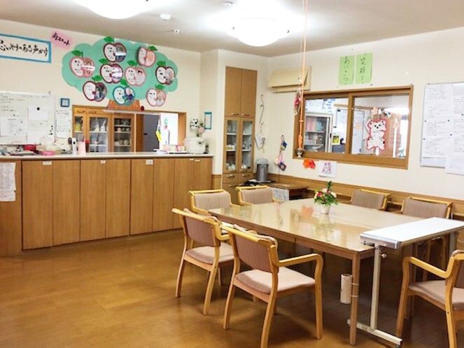 対面式のキッチンがあるスペースには大きなダイイングテーブルが置かれ、花が飾られている。