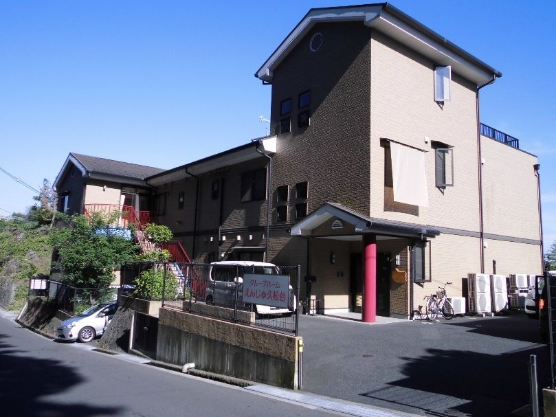 緑に囲まれたブラウン系の外壁の３階建ての建物にはベランダや屋上もあり、日当たり良好。