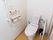 温水洗浄便座器が完備されているトイレである。壁には、緊急呼び出しブザーやL字型手すりが設置されている。