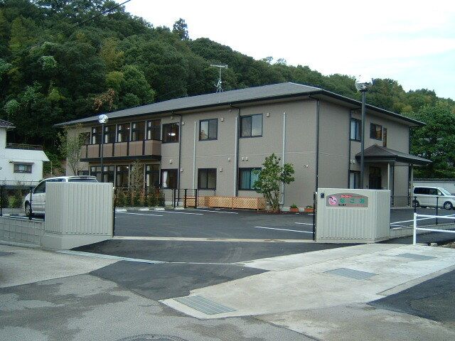 広い庭園があるホーム。２階建ての建物の１階部分にはウッドデッキ、２階部分にはベランダがある。