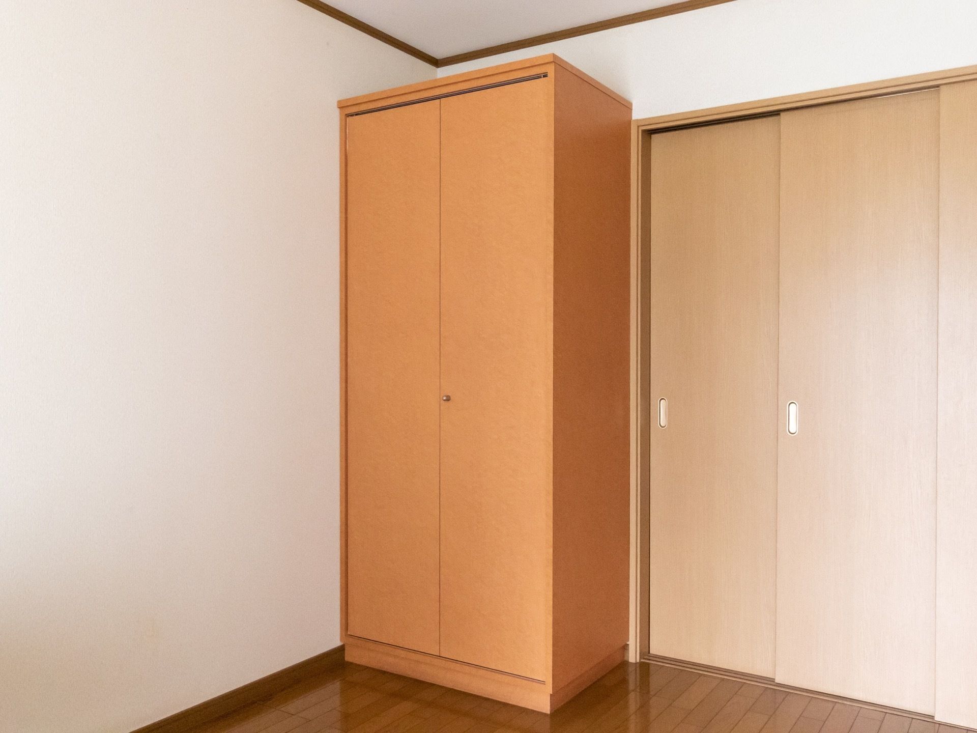 居室のドアを入ると、右手に据え置きのクローゼットがある。背が高いので、丈の長い物も収められる。