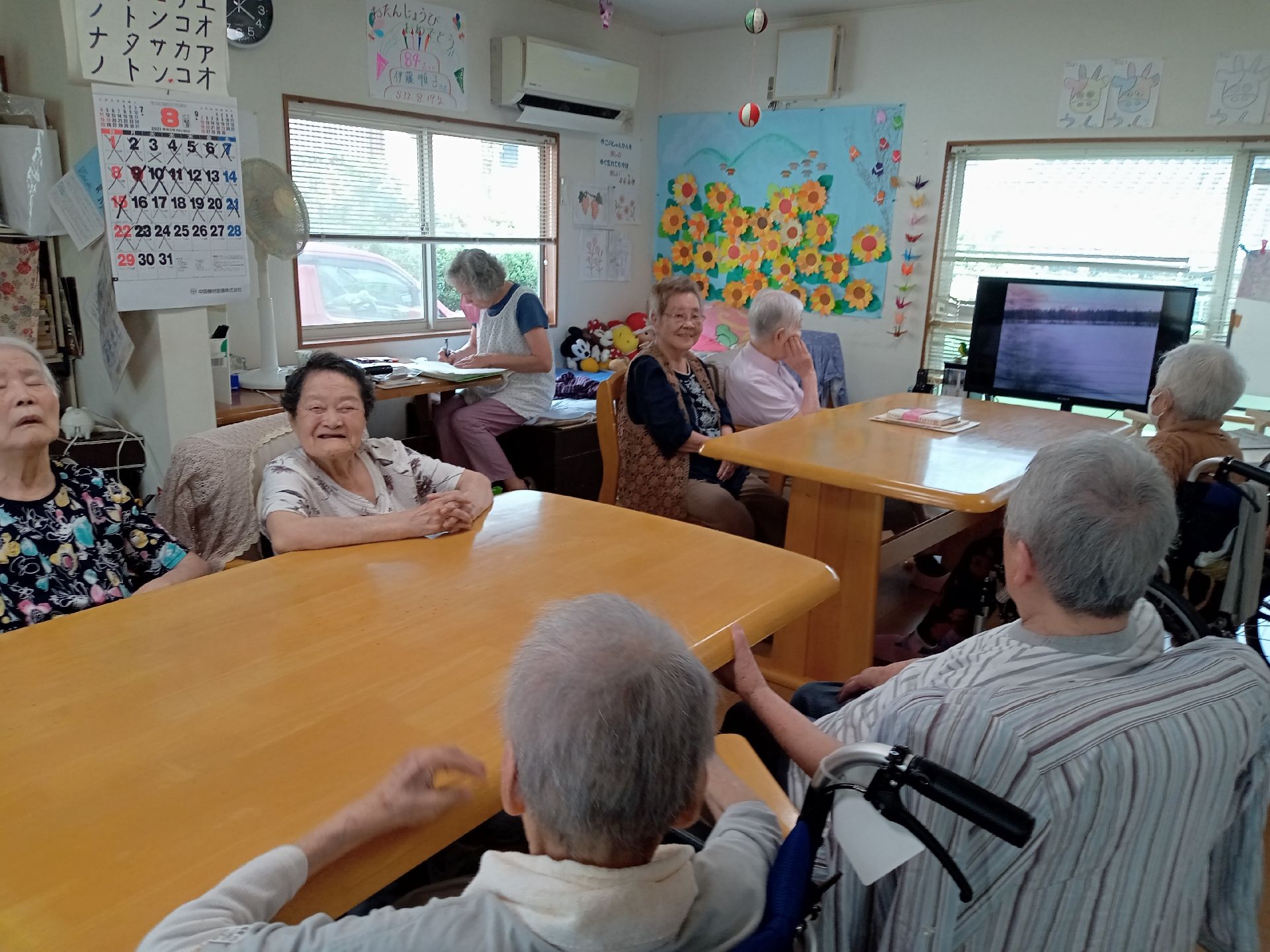 施設内のリビングに利用者が集まっている様子。家庭的なリビングスペース