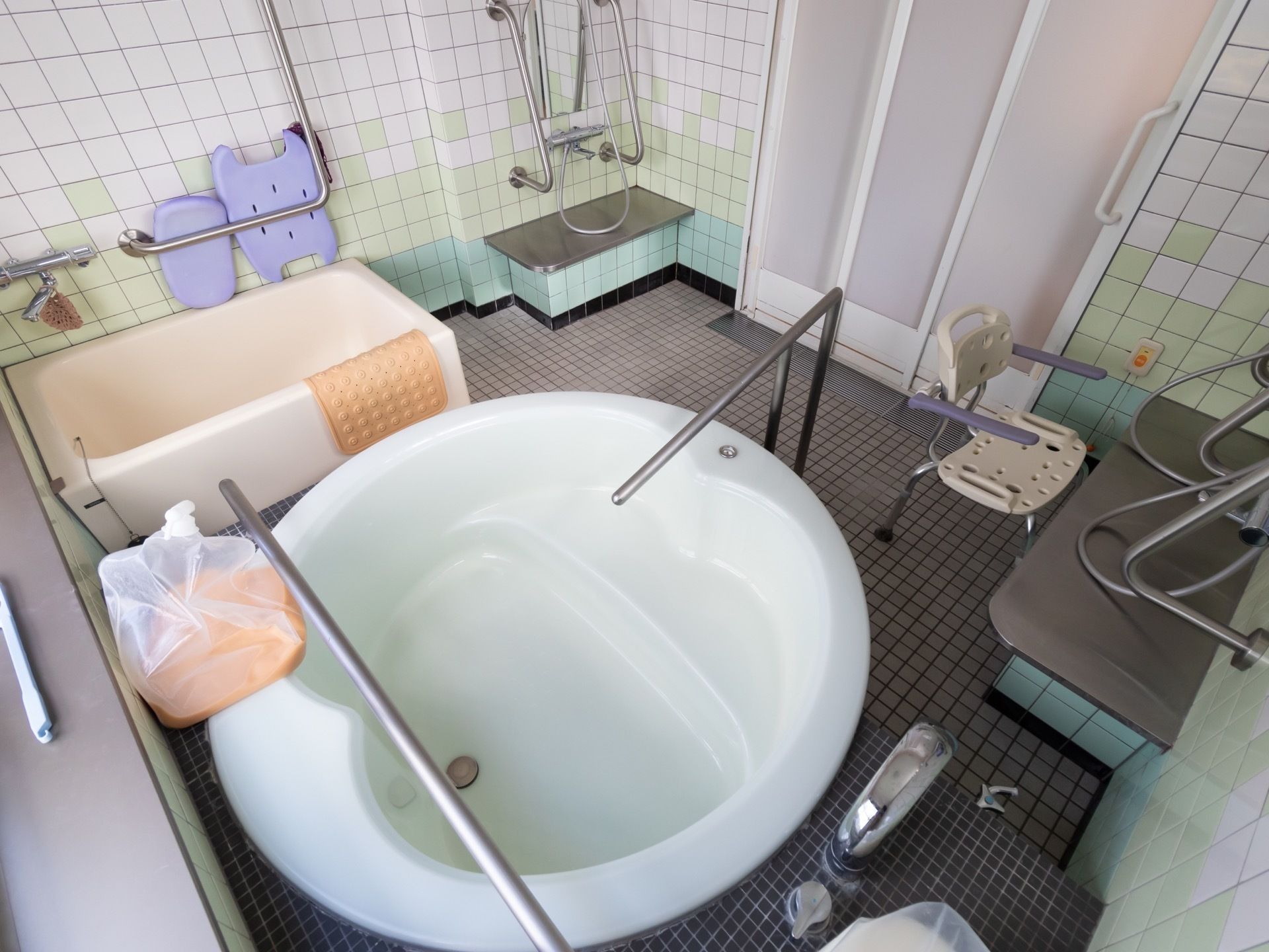 浴室には大きな白色の丸い浴槽が設置されている。手すりがあり、体を支えながら出入りすることができる。床や壁はタイル張りになっている。