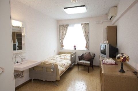 ハートフル稲毛の居室。広い空間に介護用ベッドやエアコン、洗面台などを完備している。