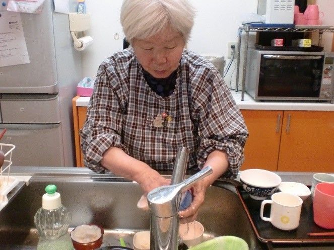 お手伝いする高齢の女性のキッチン