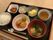 お茶や白いご飯、みそ汁、ヒジキ、揚げ物、野菜の和え物、卵豆腐などが並んでいる。