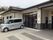 シルバーの車が建物の前に泊まっている。建物は平屋建てで、大きな窓が付いている。