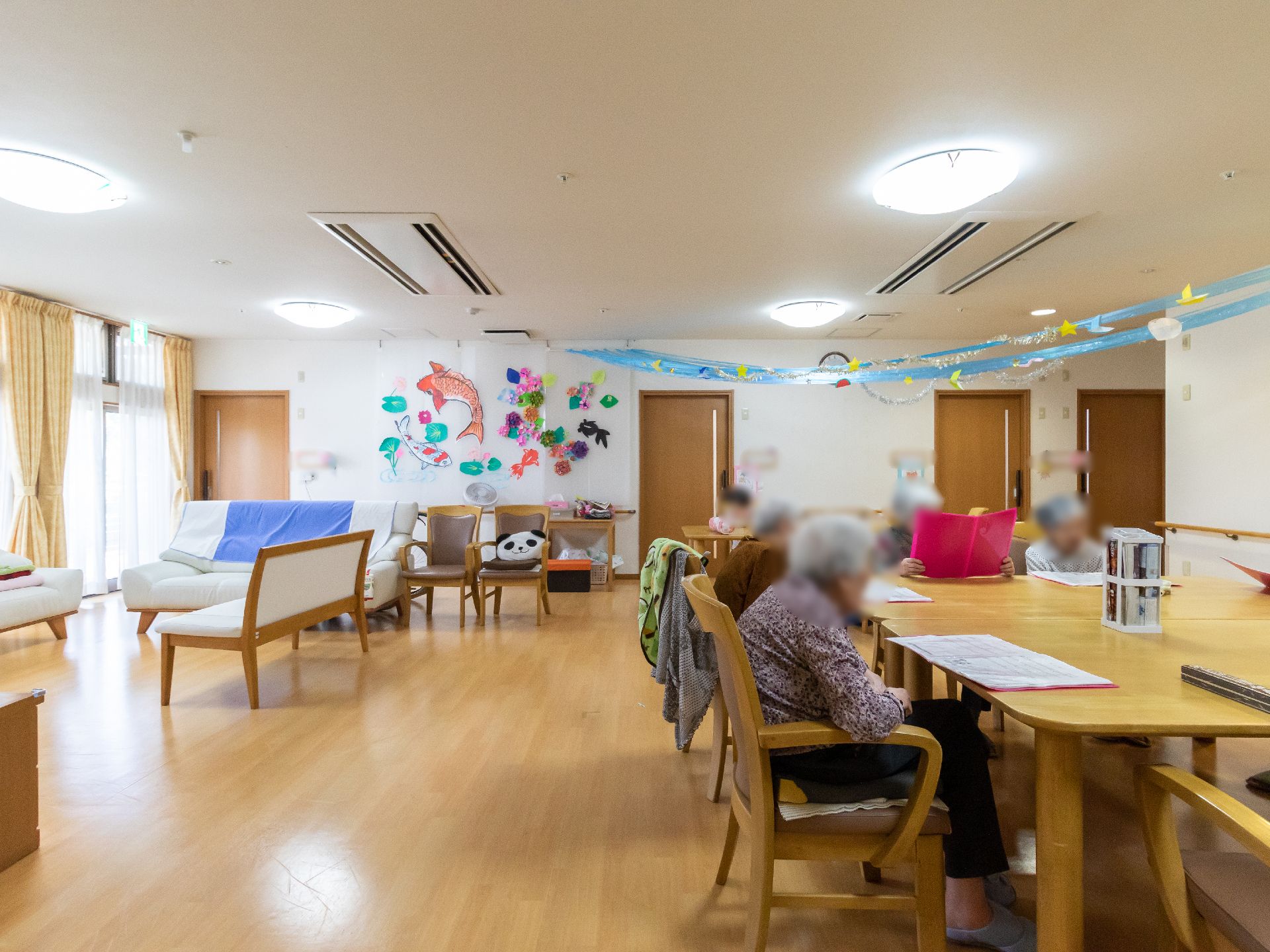 面積が広く、テーブルの周りに入居者が座っているリビング