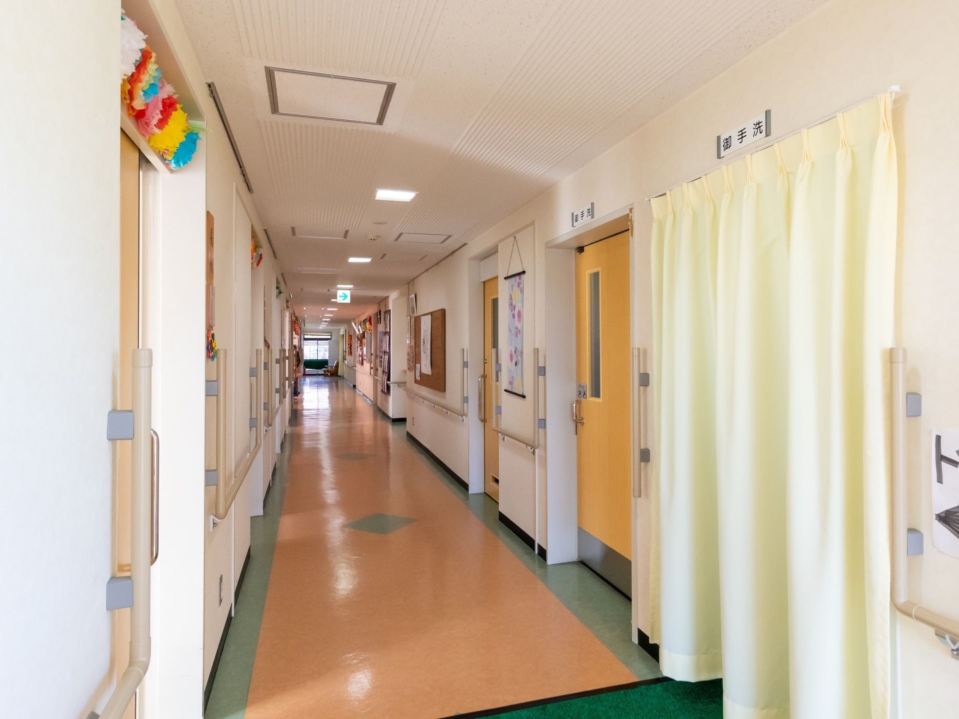 オレンジと緑のパステルカラーで配色された床は可愛らしくほのぼのとしている。ドアの上にはネームプレートがあり場所がわかりやすい。